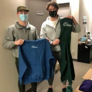 Kobe Seguin and Adam Kennedy hold up hoodies